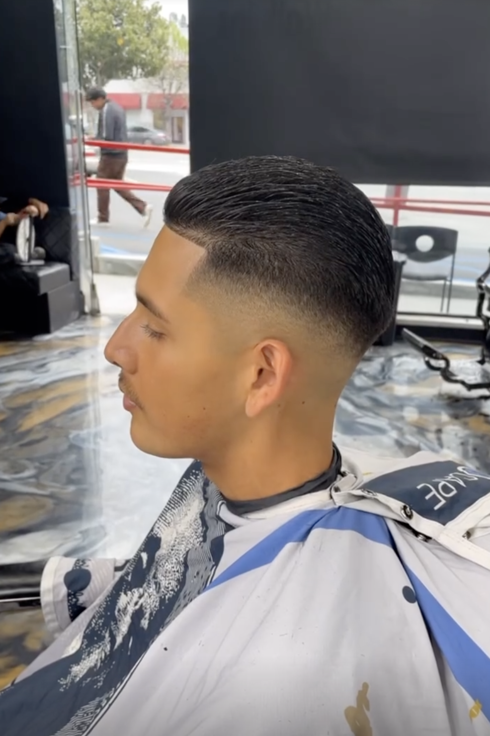 Slicked back fade haircut in the barber chair