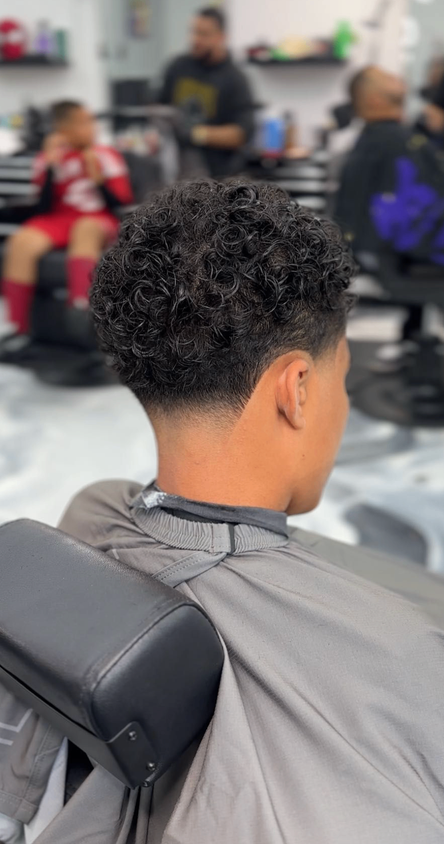 Curly taper haircut from the back